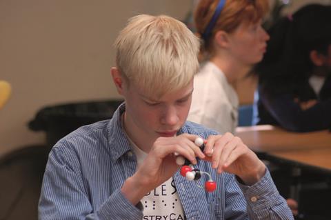 A visually impaired student holding a molecular model