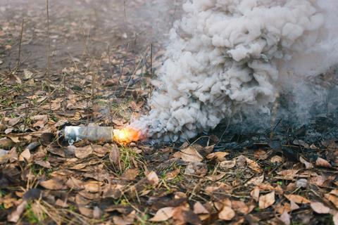 Grey smoke grenade on a forest floor