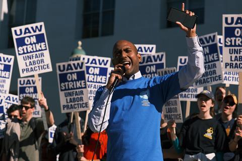 Postdoc in a blue shirt giving a speech