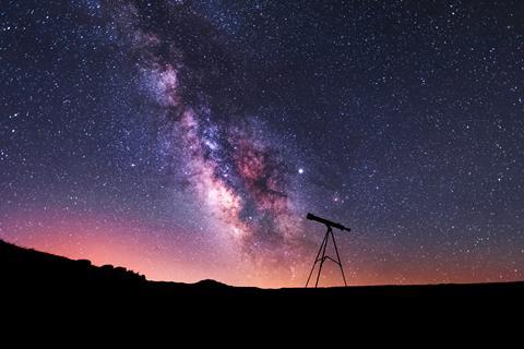 Telescope in front of milky way starscape